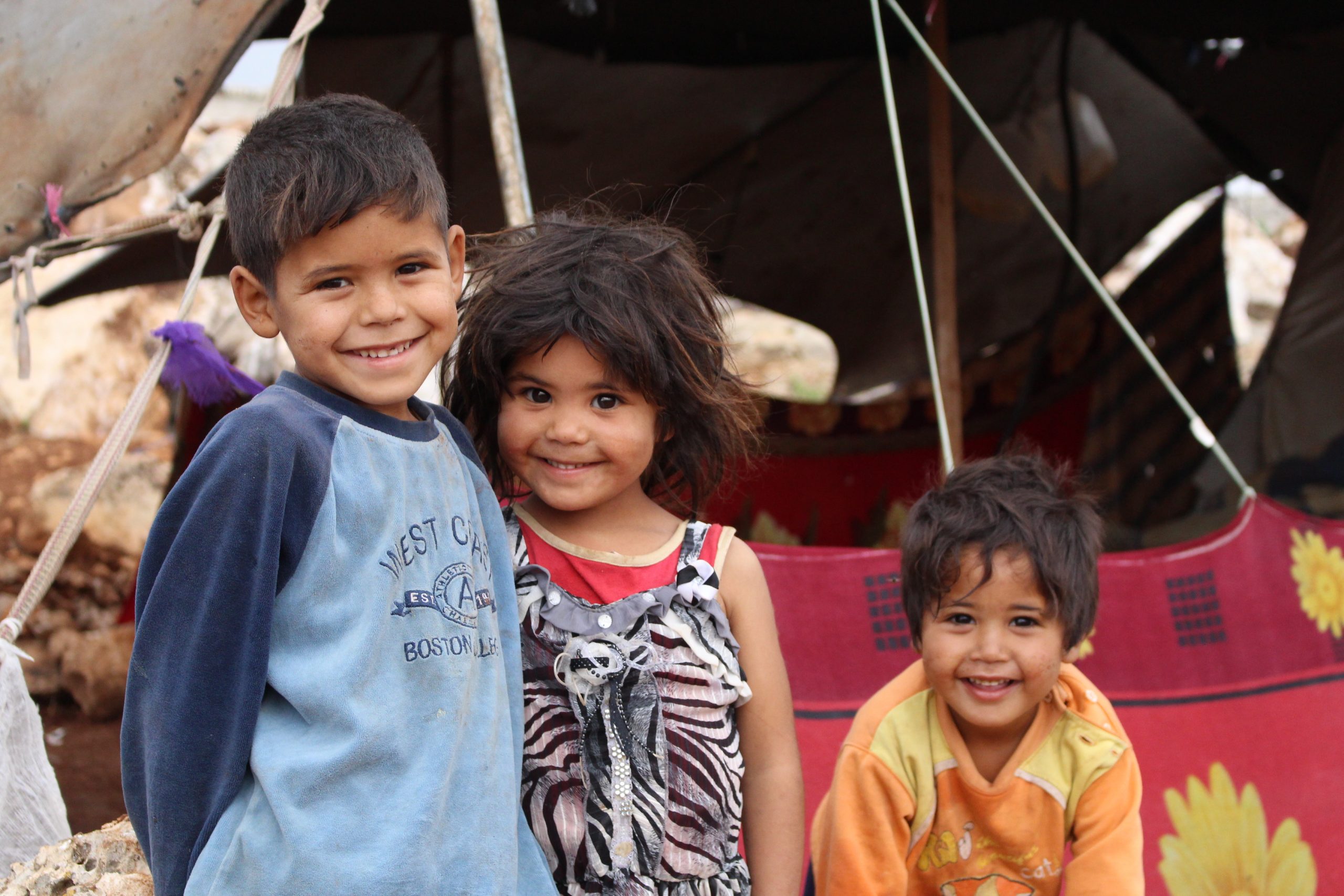 Three children smiling in Syria