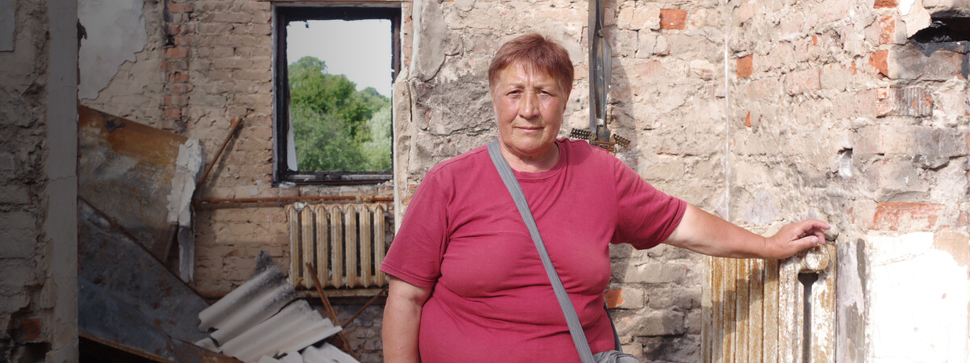 Woman standing in the middle of a destroyed home