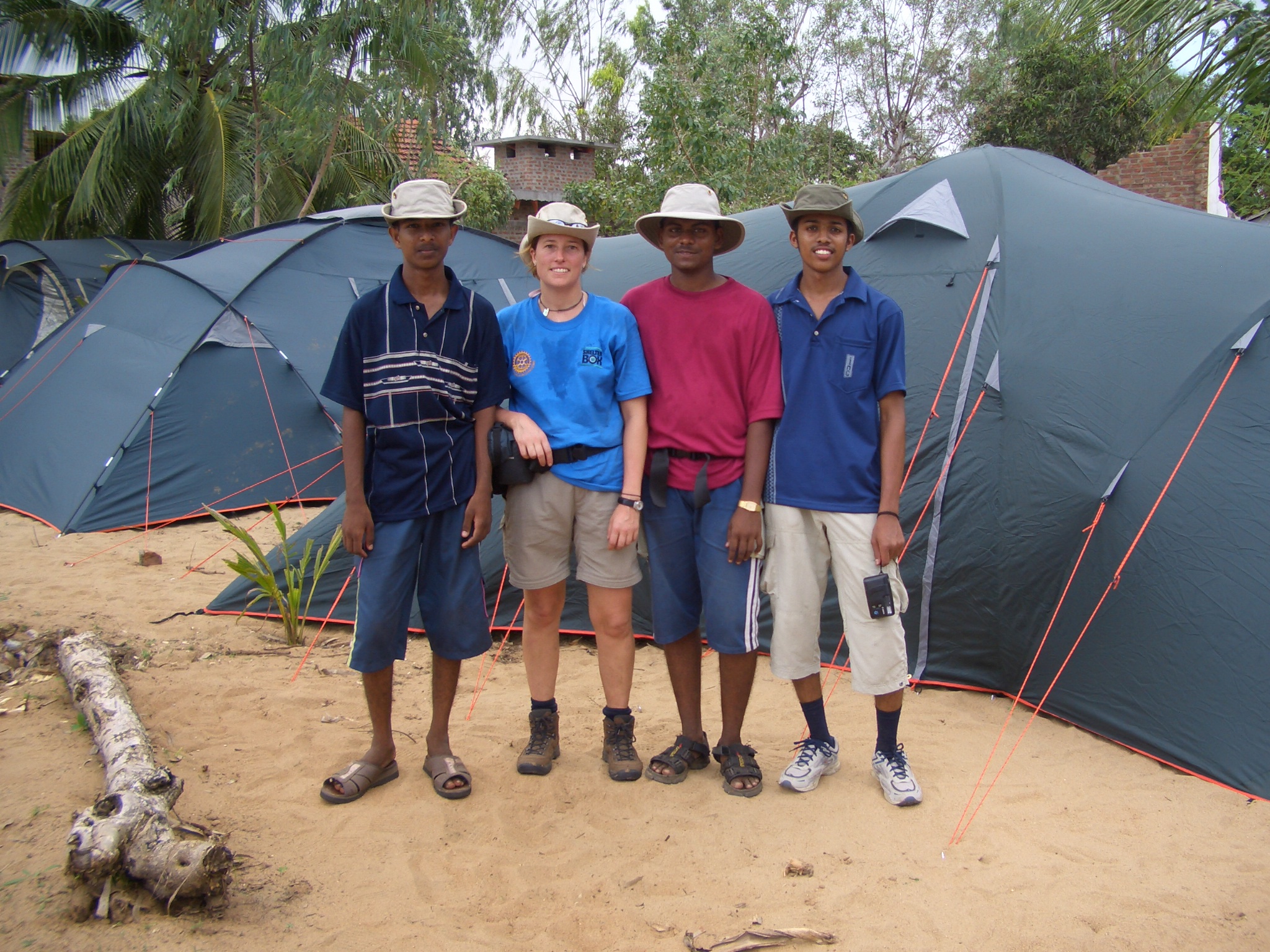 A group of 4 people posing in front of tents in Sri Lanka, following the Boxing Day Tsunami of 2004