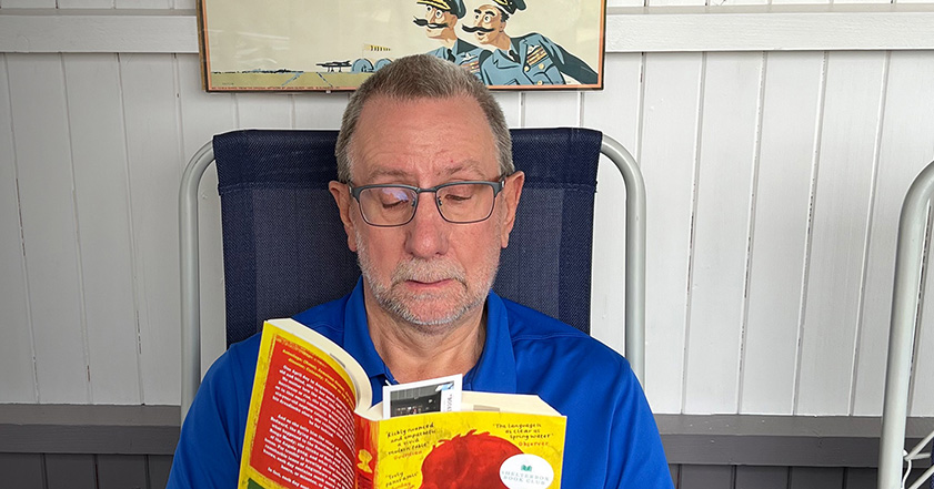 Man sitting in chair reading a book