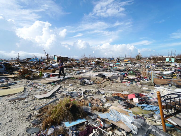 Man walks amongst widespread destruction in the Bahamas in 2019, following hurricane Dorian