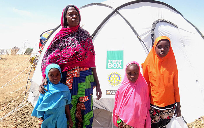 Woman and three children stand in front of a ShelterBox tent in Cameroon