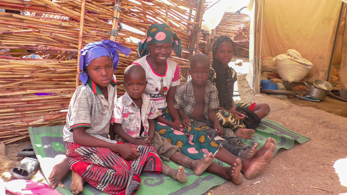 Woman and four children sitting on a mat at Minawao Camp in Cameroon.