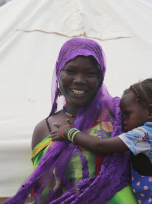 Woman holding her child outside a tent in Chad