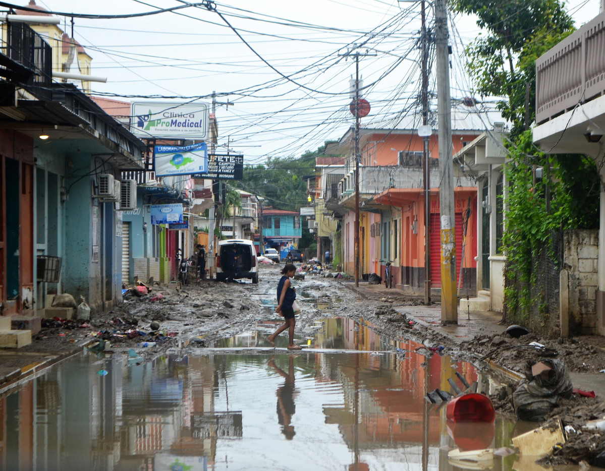 A woman walks on a flooded street in Honduras