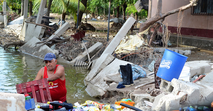 Man trying to save his possessions from flood waters in Honduras