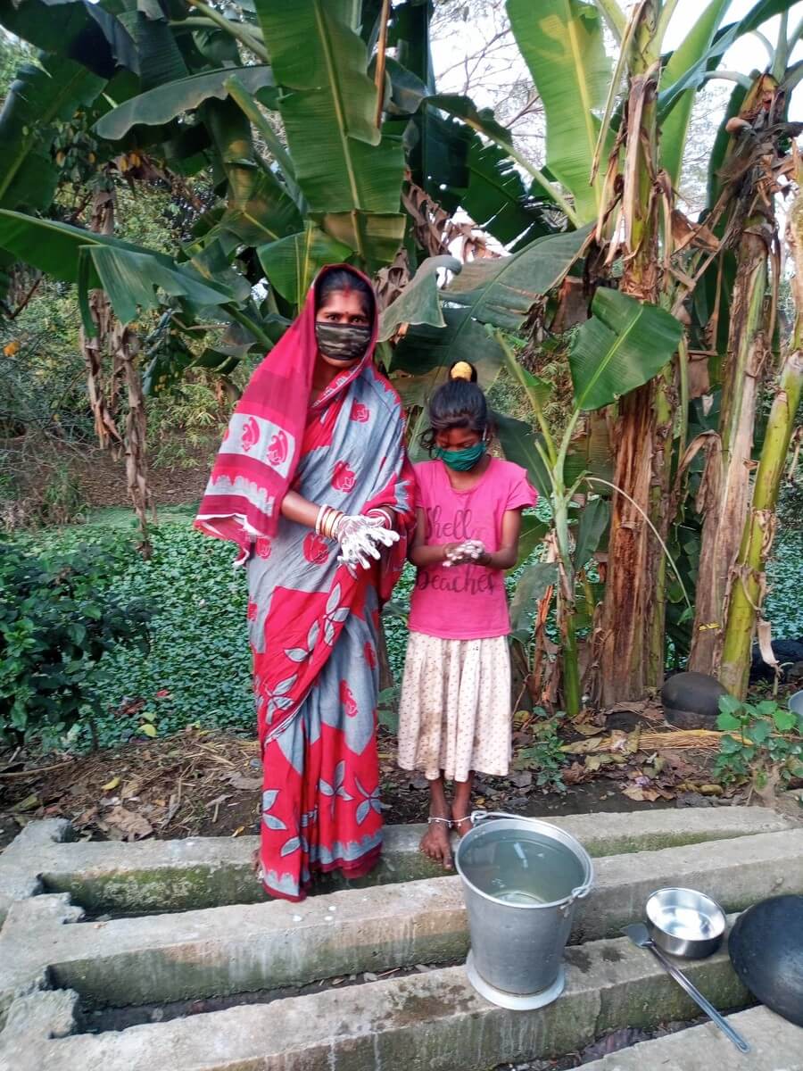Mother and daughter wash hands in India