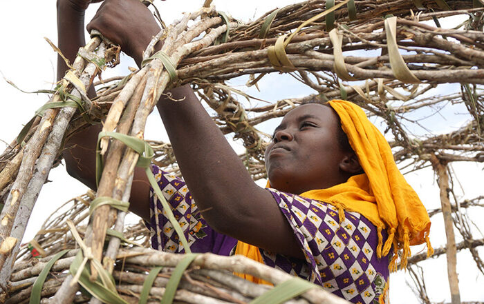 A woman constructing a home in Kenya