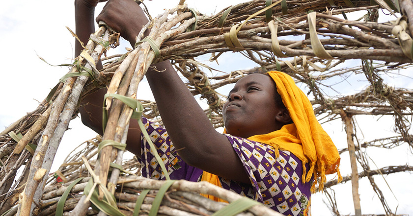 A woman constructing a home in Kenya