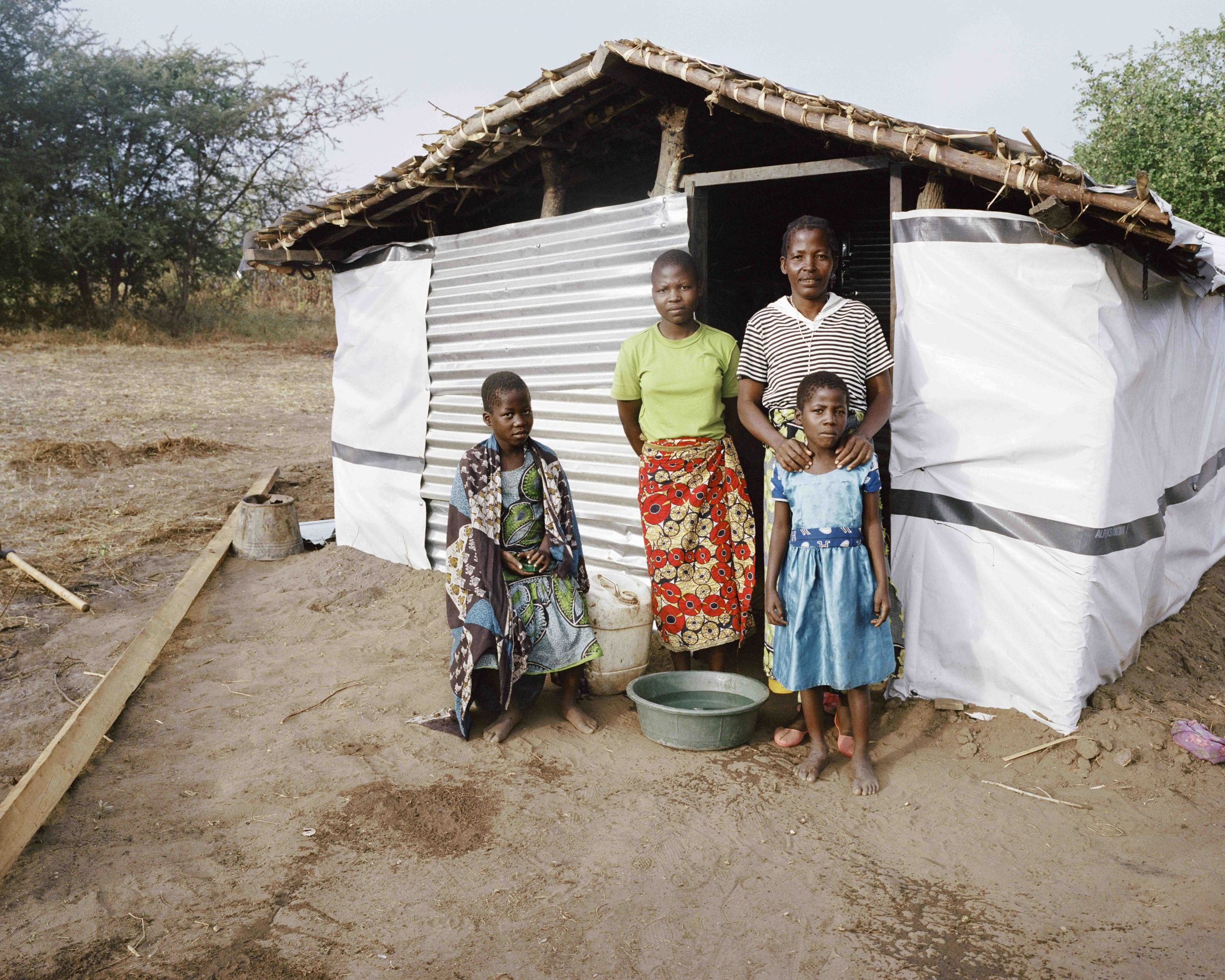 Family standing outside a home in Mwalija village, Malawi
