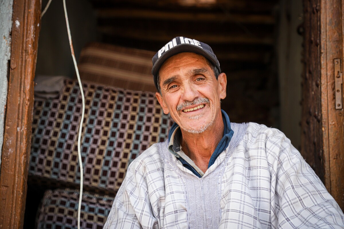 Man sitting in the doorway of his damaged home after the September 2023 earthquake in Morocco