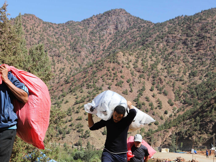People carrying bags of aid in the Atlas Mountains in Morocco