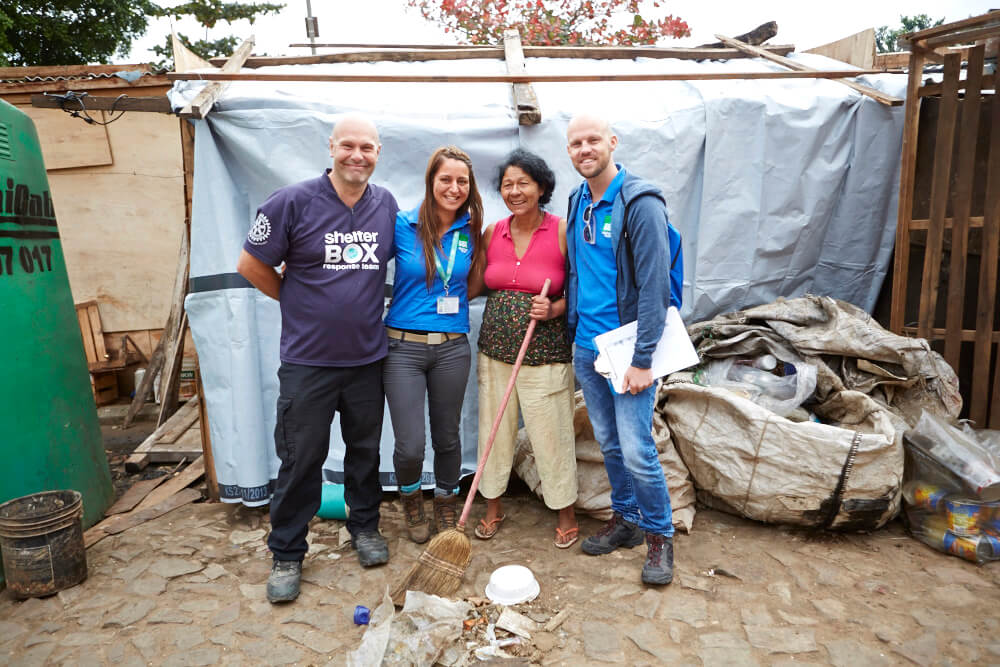 Aid workers standing next to a shelter in Paraguay after flooding in 2014.