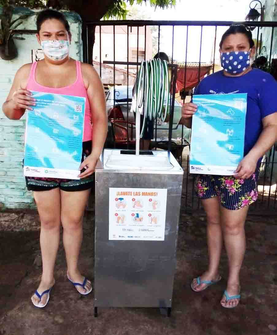 Women hold information signs about coronavirus in Paraguay