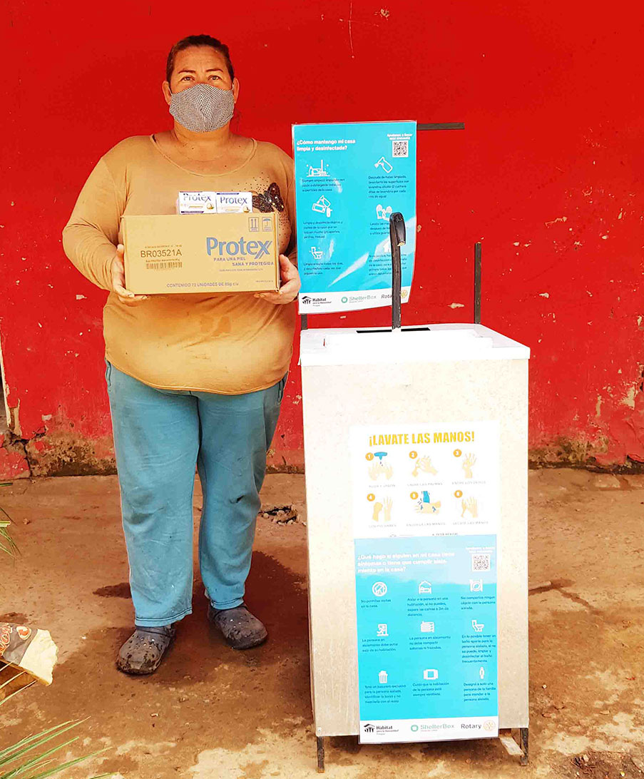 Woman stands next to information signs about coronavirus in Paraguay