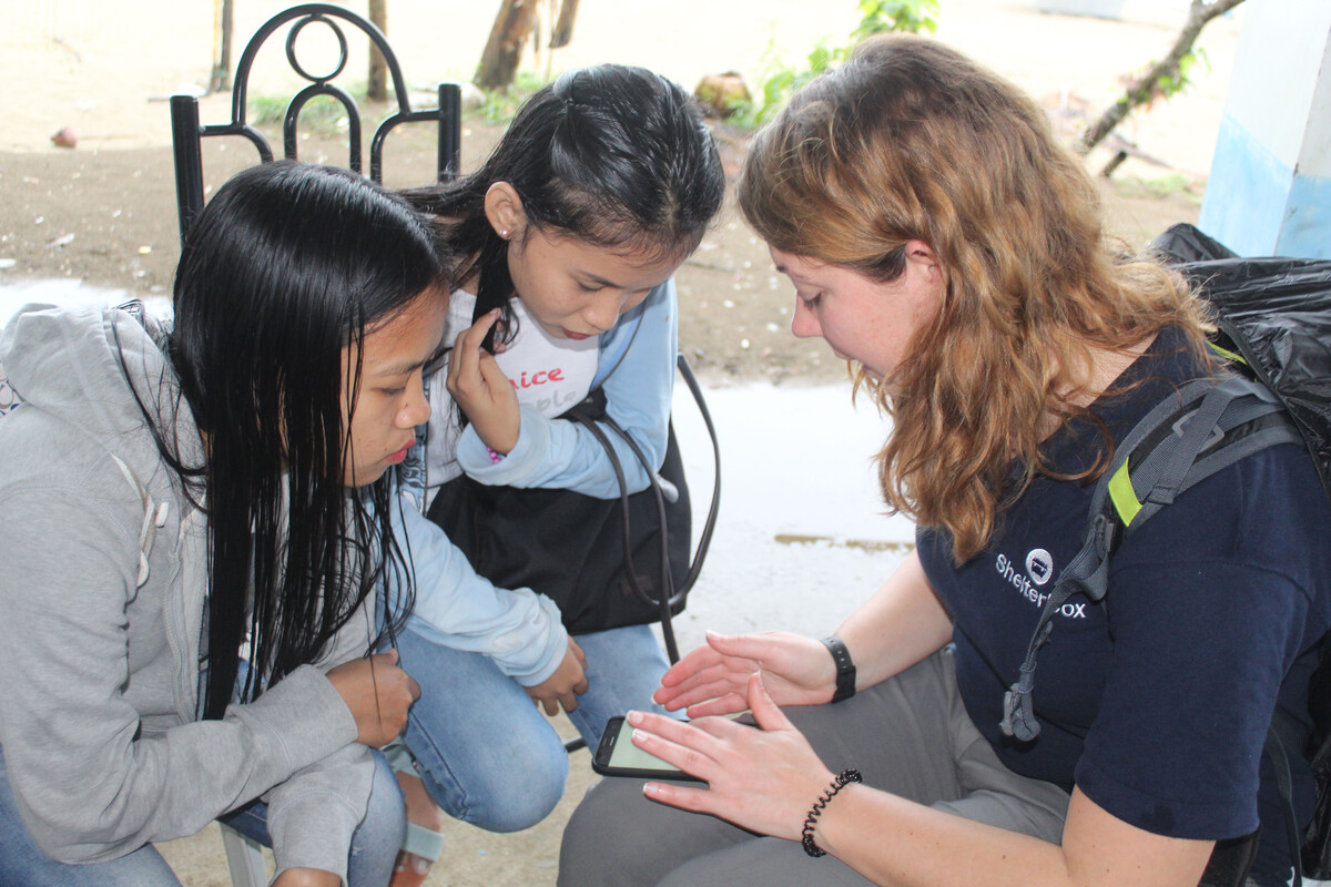 Three people looking at a screen in the Philippines