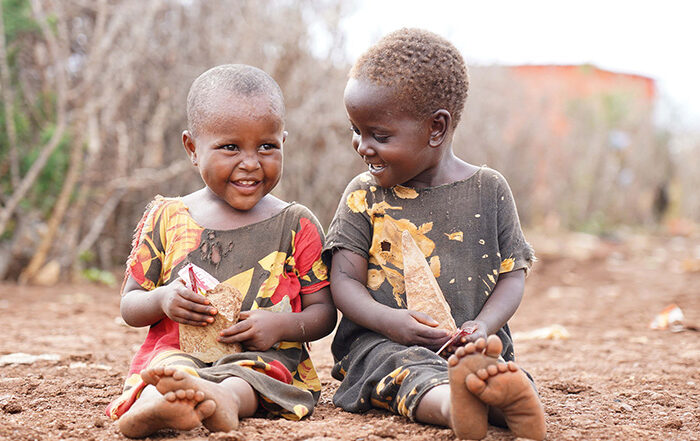 Two young boys sitting on the floor and smiling in Somalia