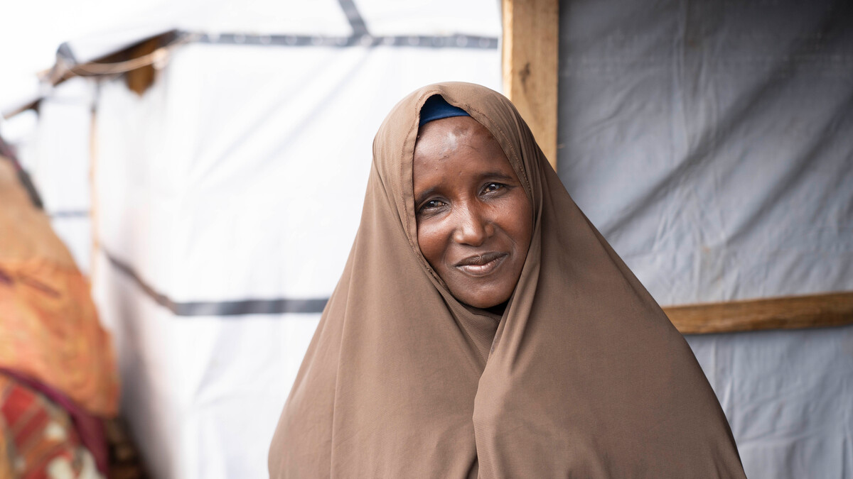 Woman standing outside a durable shelter in Somalia