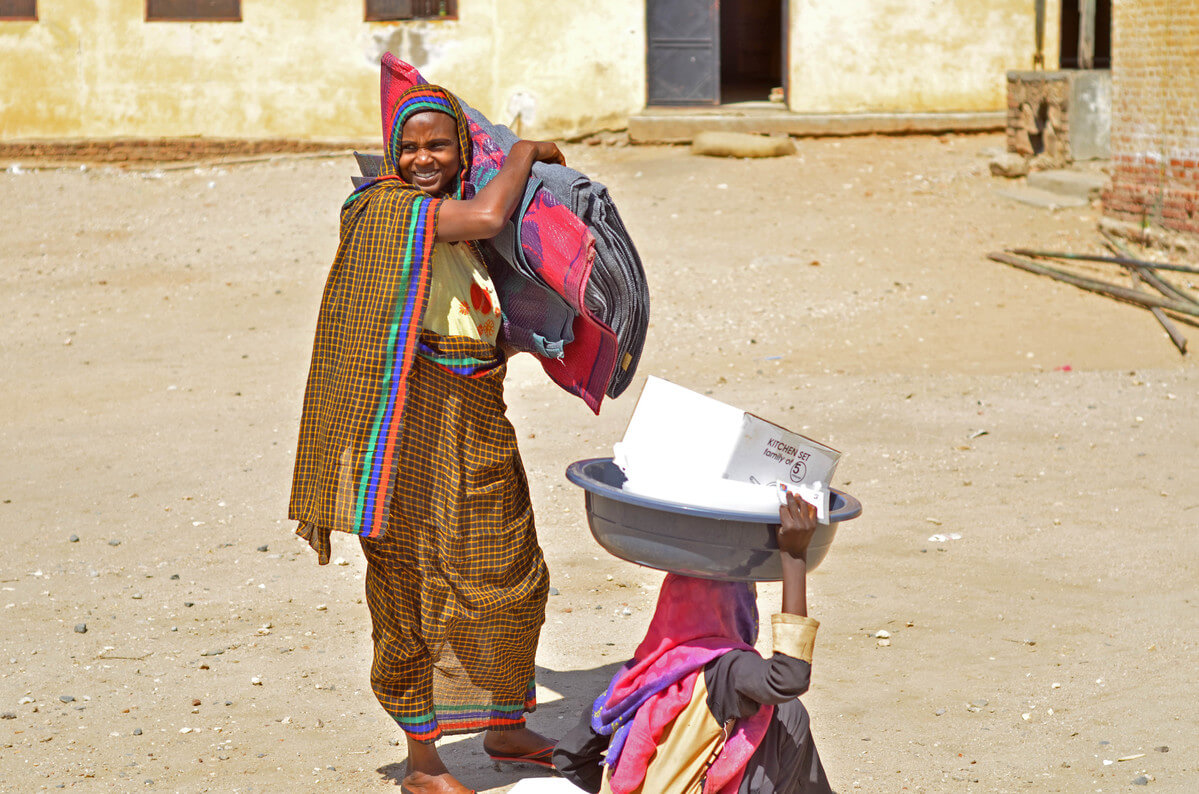 Woman carries ShelterBox aid in Sudan