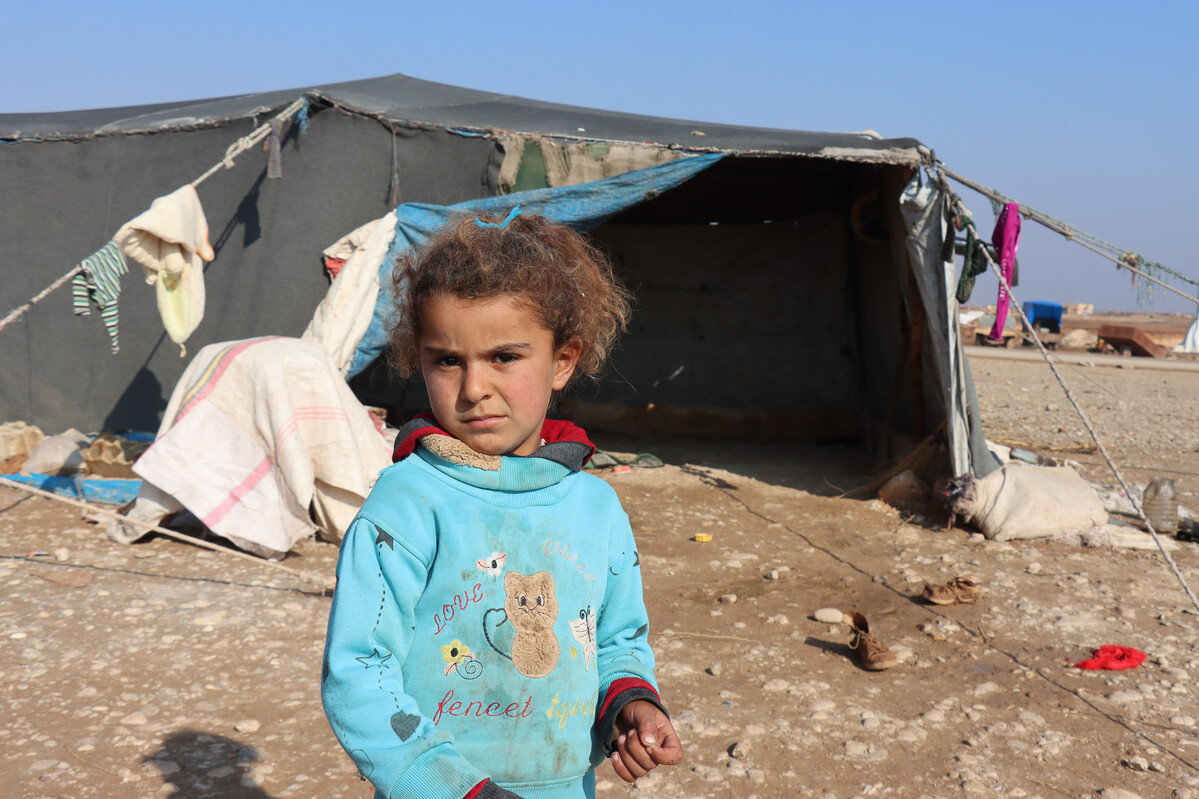 Girl standing in front a tent in Syria