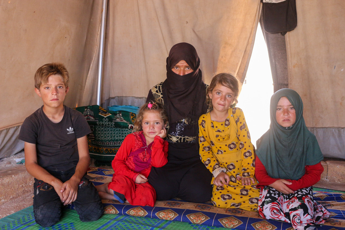 A woman sat down with her 4 children inside a shelter in Syria