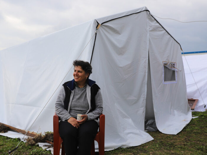 Woman sitting outside a tent in Turkey after the earthquakes