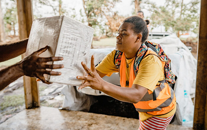 Woman passing bag of aid in Vanuatu