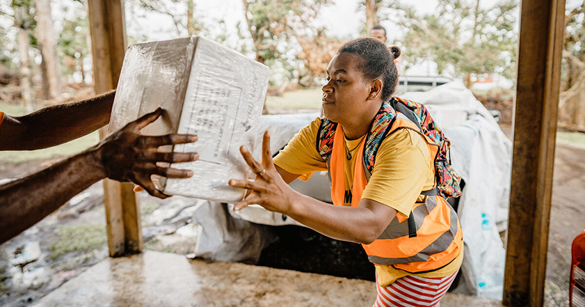 Woman passing bag of aid in Vanuatu