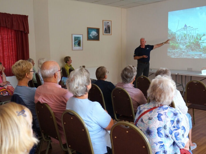 Man with a projected display speaking to an audience