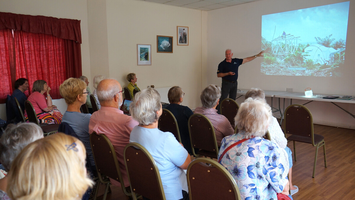 Man with a projected display speaking to an audience