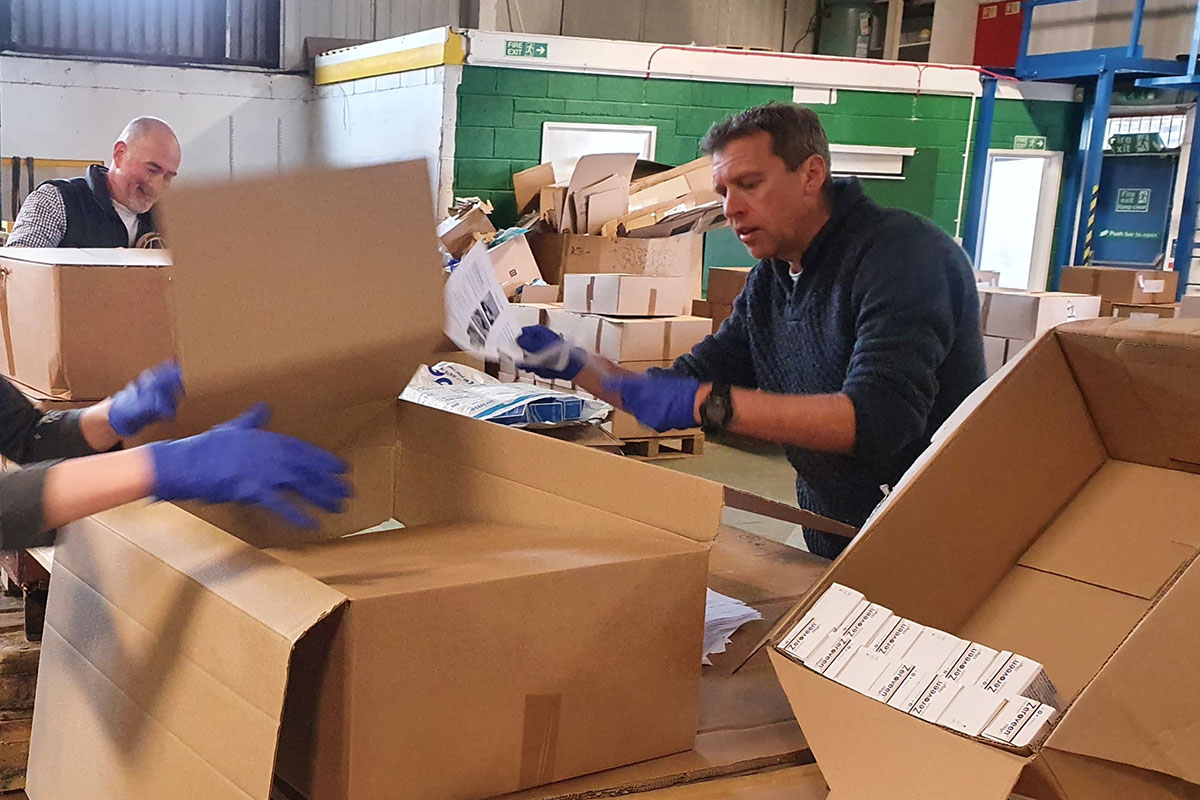 Cardboard boxes being packed with care items in the ShelterBox warehouse