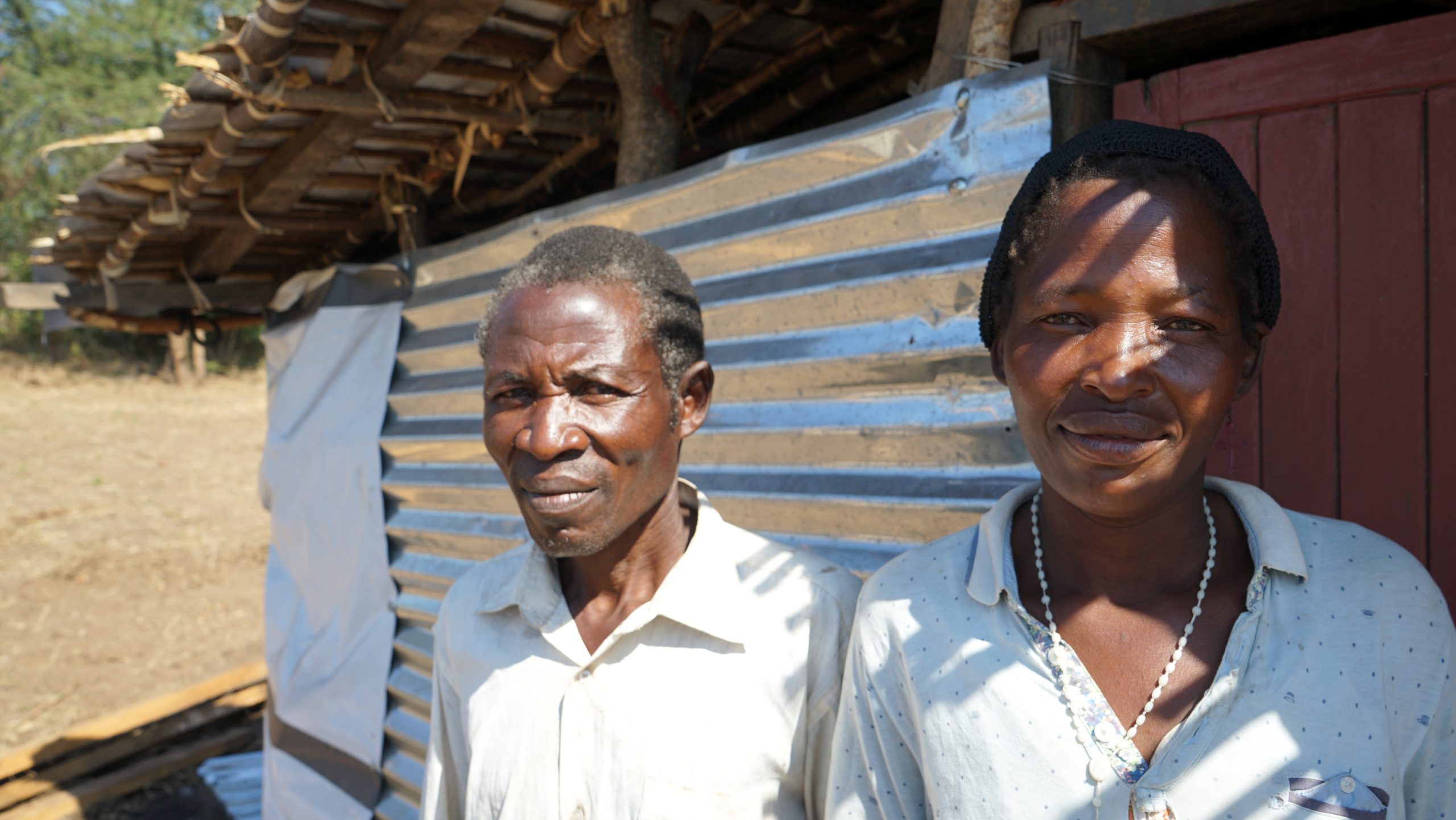 Man and woman standing outside a shelter in Malawi after their home was destroyed by Cyclone Idai