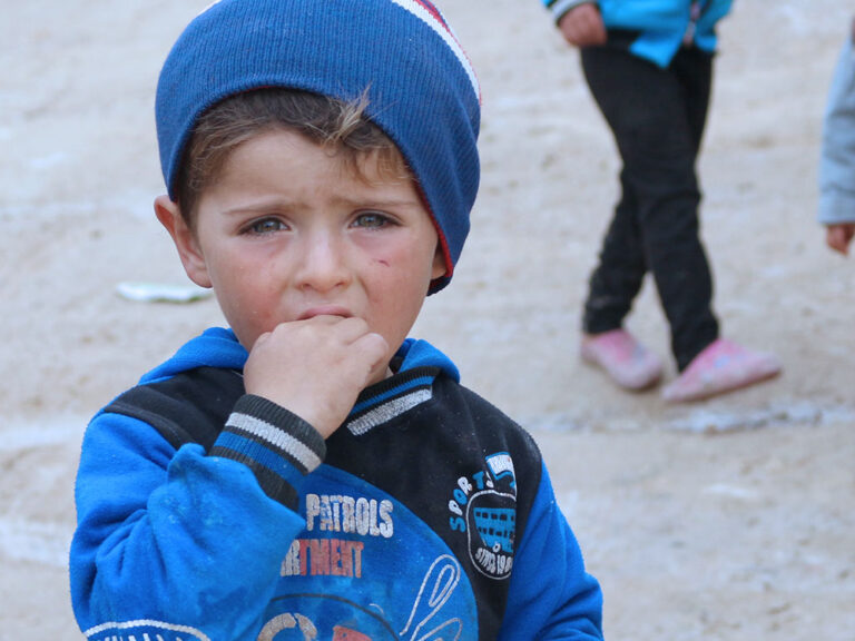 Displaced Syrian boy bites his hand
