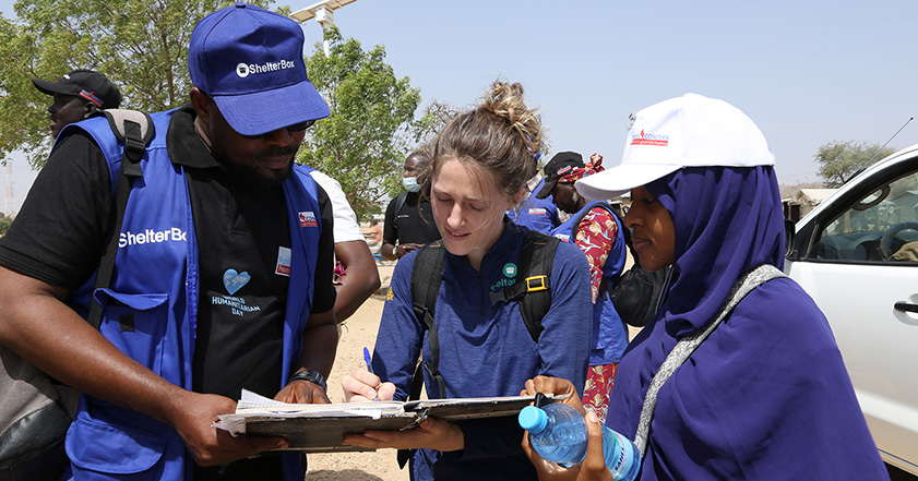 Three people looking at paperwork while on deployment as humanitarians