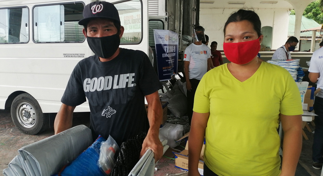 Man and woman wearing masks in the Philippines whilst collecting ShelterBox aid