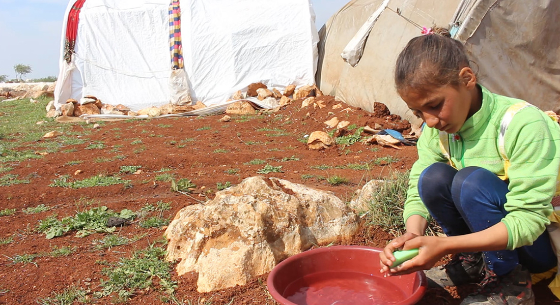 Girl in a Syrian camp washing her hands with soap to help protect against coronavirus