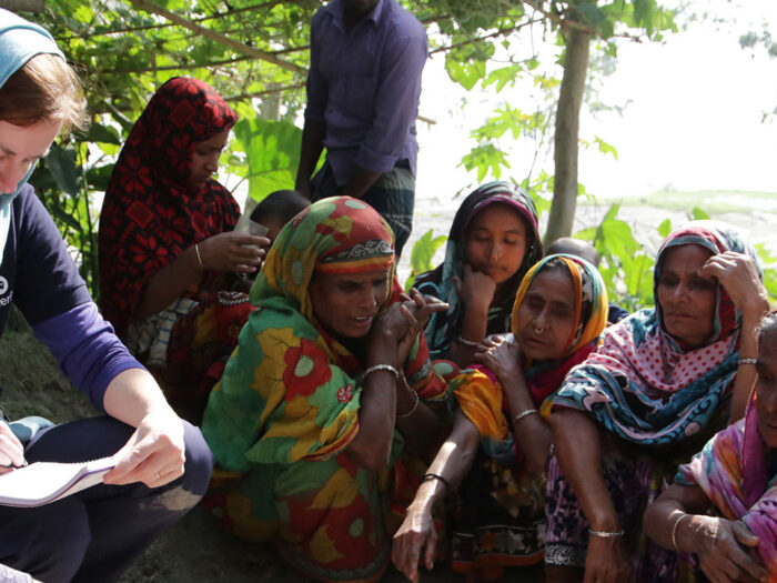 ShelterBox team member taking notes while talking to people in Bangladesh