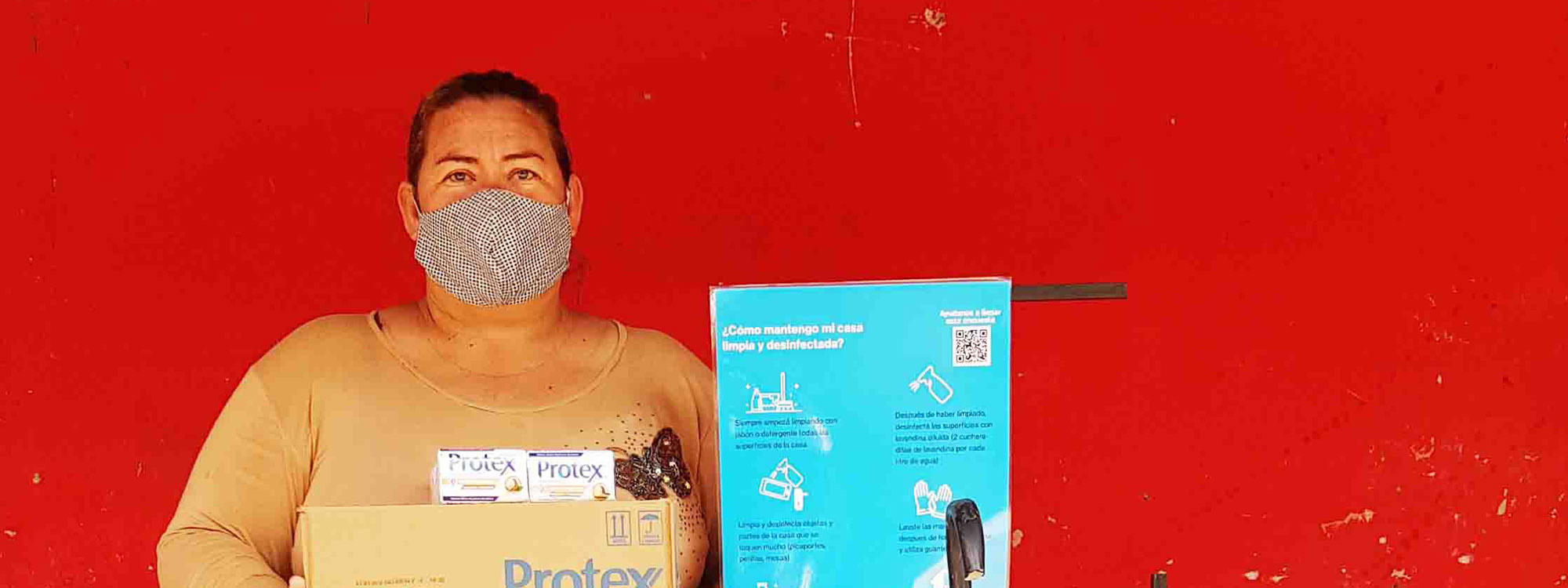 Woman wearing facemask next to a poster with coronavirus information in Paraguay