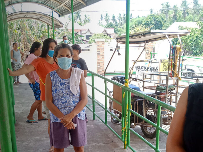 People queuing for aid in the Philippines socially distanced and wearing facemasks during the coronavirus pandemic