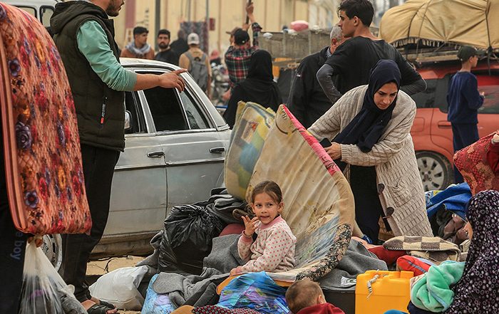 People holding belongings in the street in Gaza