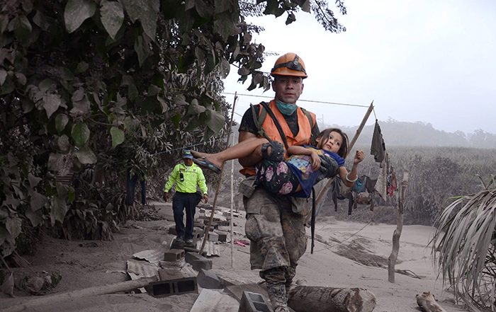 Man carrying child after Guatemala volcano eruption