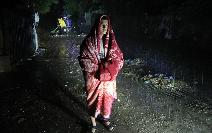 Man standing in heavy rain during Storm Daniel in Libya