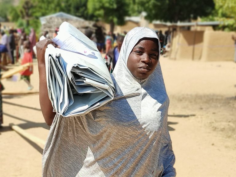Woman carrying tarpaulins in Cameroon