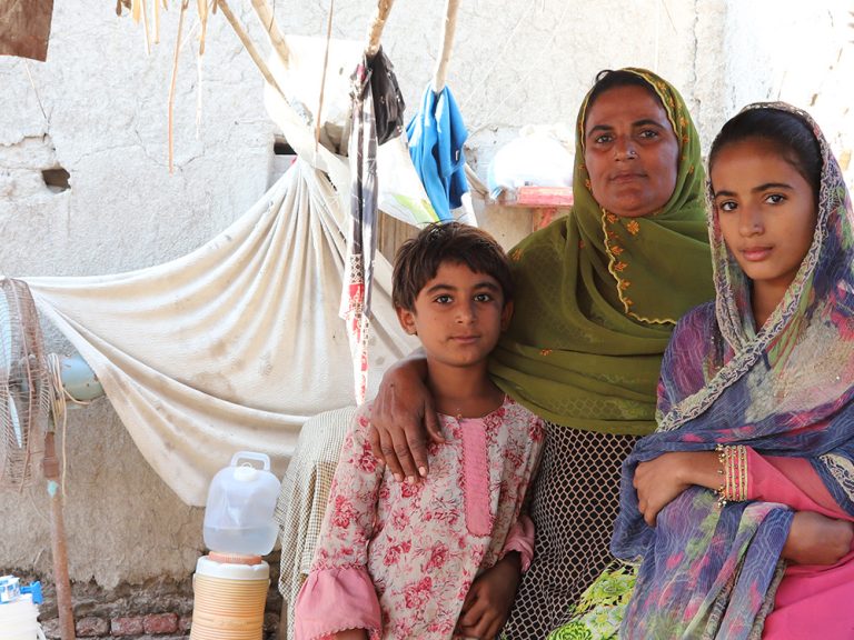 Woman and two children sitting in a shelter in Pakistan