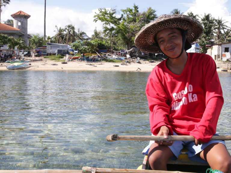 Person sitting in a boat of the coast of the Philippines