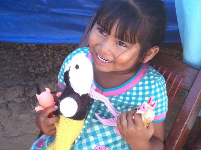 Small child holding a toy and smiling