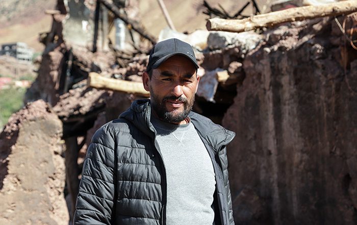 Man standing in remains of a house destroyed in an earthquake in Morocco