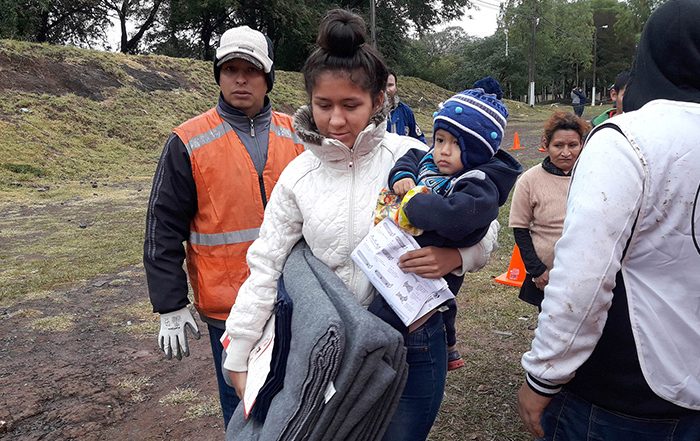 Woman carrying child and aid in Paraguay