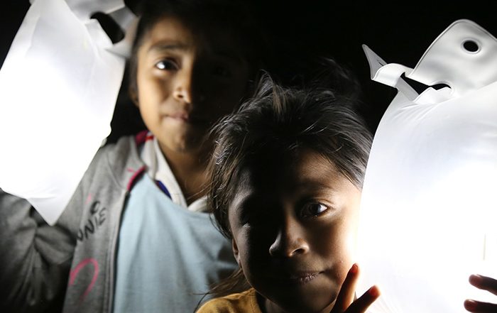 Two children holding solar lights