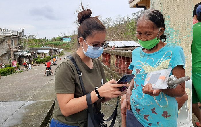 People wearing facemasks holding aid in Philippines